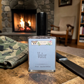 Ozark perfume 'Valor' perfume bottle on a wooden surface with a fireplace in the background
