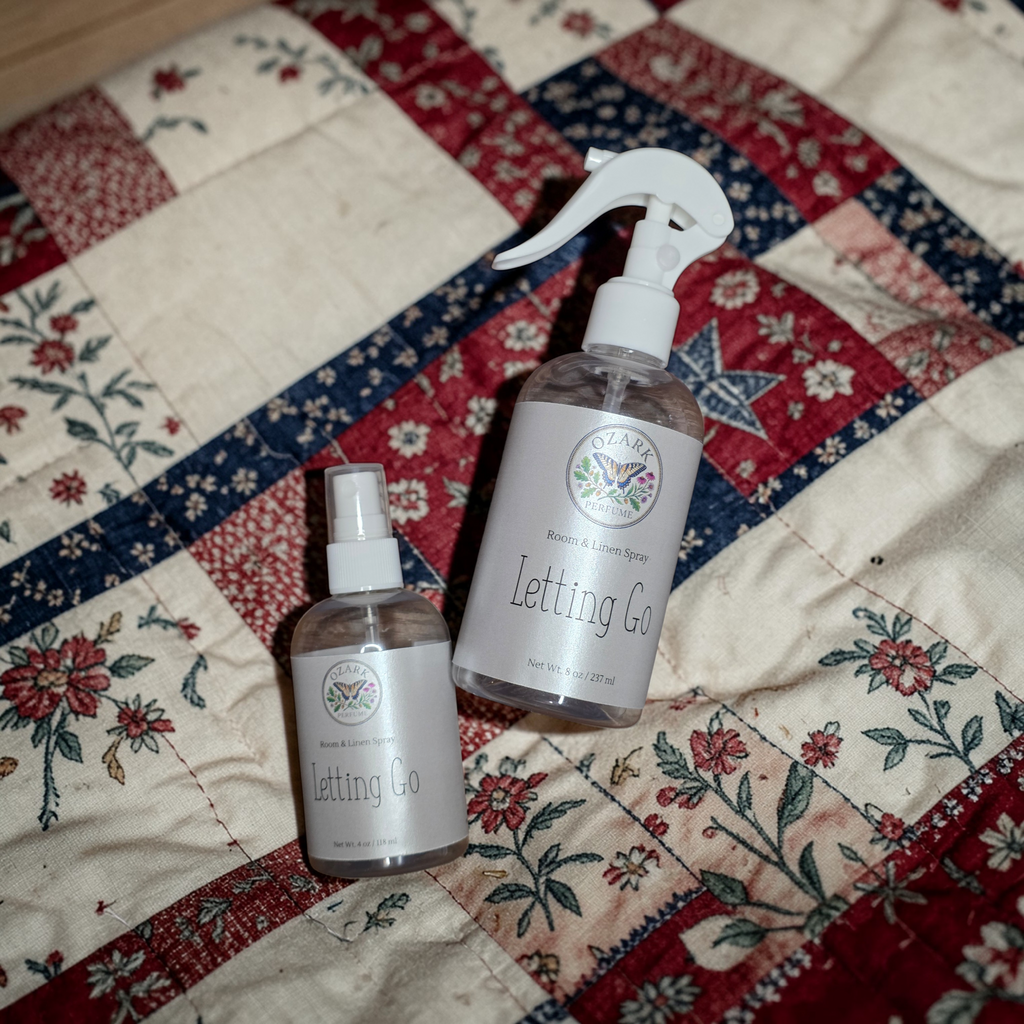 Two bottles of 'Letting Go' on a patchwork quilt