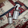 Two bottles of 'Letting Go' on a patchwork quilt