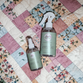 Two Serenitea bottles on a patchwork quilt with floral patterns