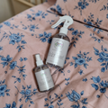 Two bottles of 'Sticky Sweet' product on a floral bedspread