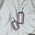Two bottles of 'Sweet Bread' on a light fabric background
