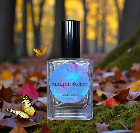 Bottle of 'Autumn Secrets' eau de parfum with a butterfly and autumn leaves in the background