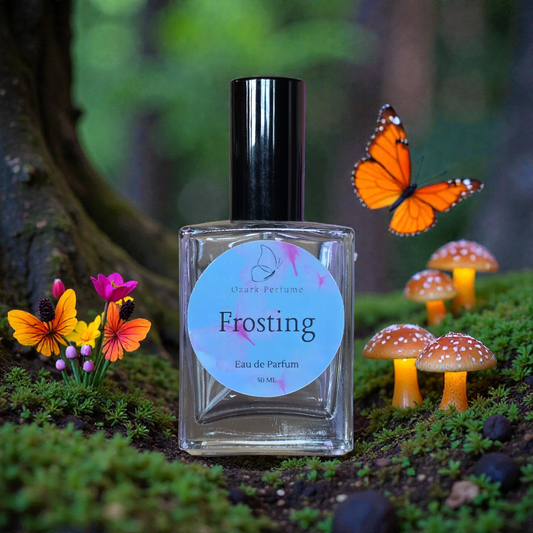 Perfume bottle labeled 'Frosting' with decorative mushrooms and butterflies in a forest setting