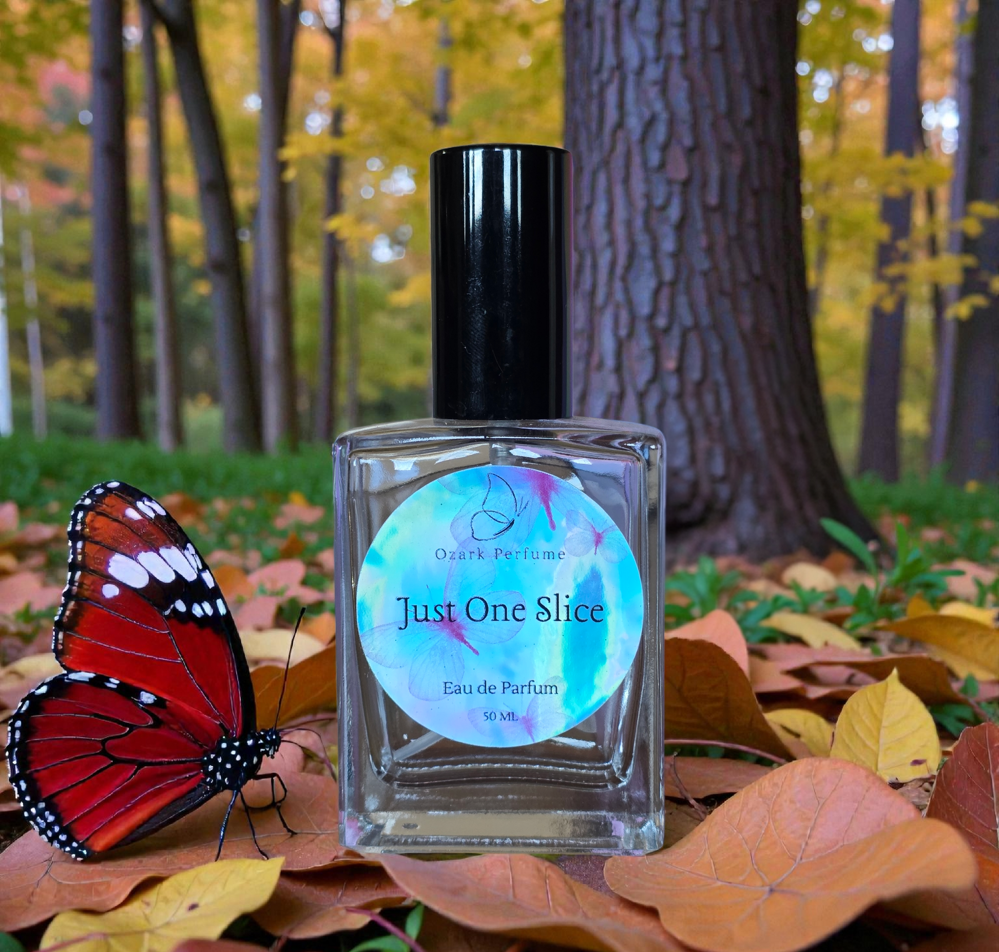 Perfume bottle labeled 'Just One Slice' with a butterfly on autumn leaves and trees in the background