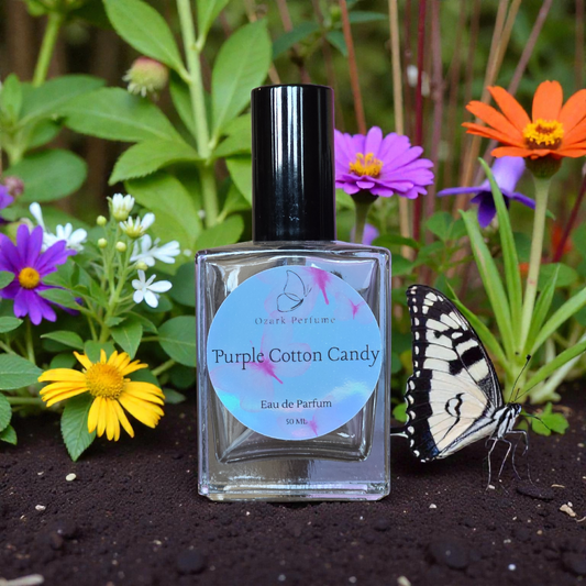 Perfume bottle labeled 'Purple Cotton Candy' with a butterfly and flowers in the background