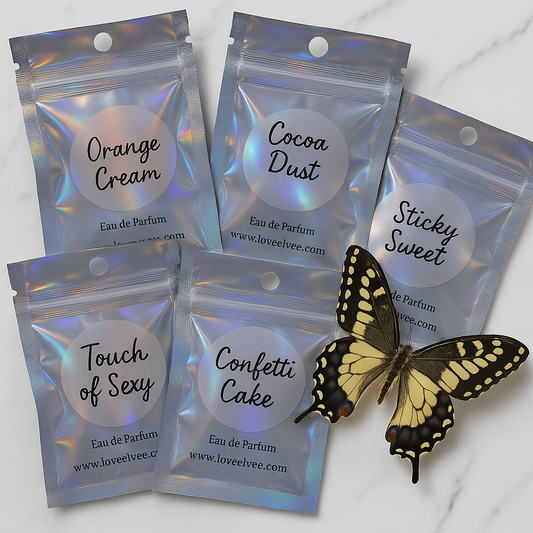 Five small perfume packages labeled 'Orange Cream', 'Cocoa Dust', 'Sticky Sweet', 'Touch of Sexy', and 'Confetti Cake' with a butterfly on a light background.