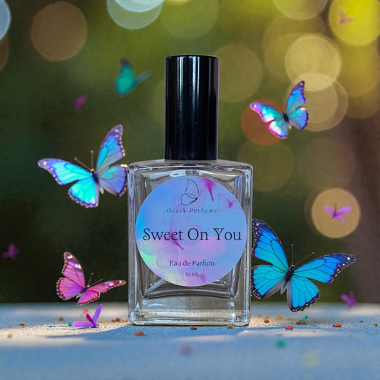 Perfume bottle labeled 'Sweet On You' with butterflies around on a blurred background