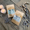 Two packages of eau de parfum with lavender and candles on a wooden surface